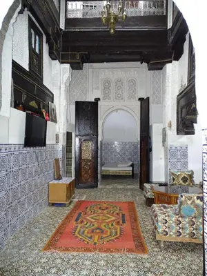 a living room with an archway and a rug on the floor at Riad Amimi Fes in Fès