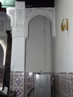 a silver refrigerator in a room with a wall with tiles at Riad Amimi Fes in Fès