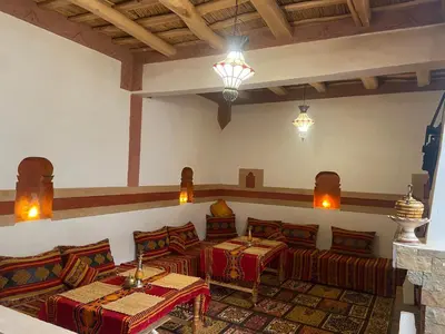 a living room with couches and tables in a room at Tafsut dades guesthouse stay with locals in Tamellalt