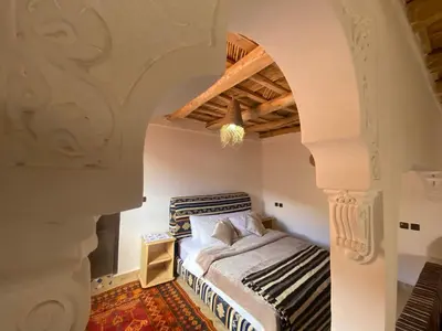 a bedroom with a bed and an archway at Tafsut dades guesthouse stay with locals in Tamellalt