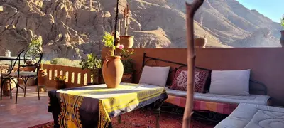 a room with a bed and a table with a vase at Tafsut dades guesthouse stay with locals in Tamellalt