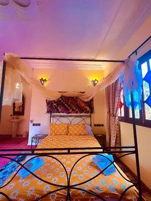 a bedroom with a bed with a canopy at Riad le Petit Jardin in Zagora