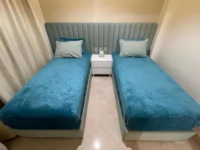 two beds sitting next to each other in a room at Magnifique appartement moderne (avec Wifi) in Fès