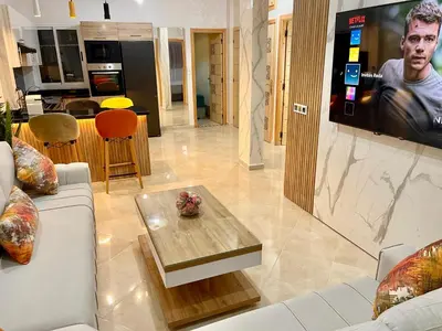 a living room with a couch and a tv at Magnifique appartement moderne (avec Wifi) in Fès