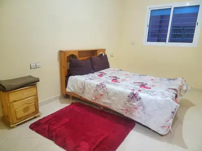 a bedroom with a large bed with a red rug at Appartement de luxe Nour in Fès