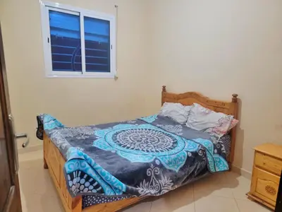 a bedroom with a bed with a wooden frame and a window at Appartement de luxe Nour in Fès