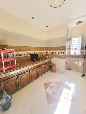 a kitchen with wooden cabinets and a counter top at Appartement de luxe Nour in Fès