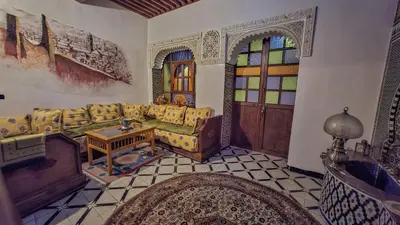 a living room with a couch and stained glass windows at Dar roeya in Fès