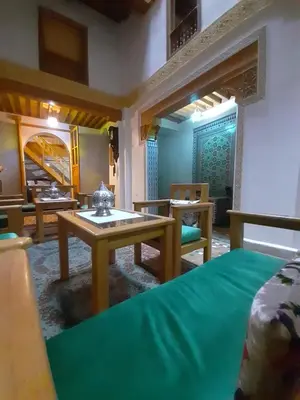a room with a bed and a table and chairs at Dar roeya in Fès