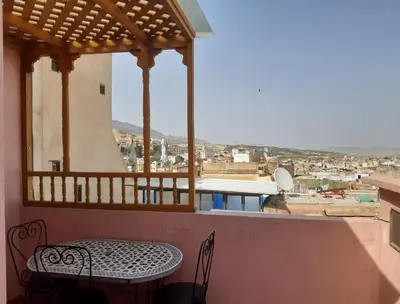 a balcony with a table and a view of a city at Dar roeya in Fès