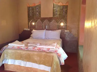 a bedroom with a bed with a painting on the wall at Kasbah Ifri in Amdnarene