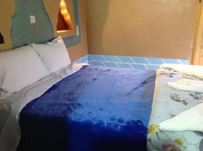 a bedroom with a bed with a blue comforter at Kasbah Ifri in Amdnarene