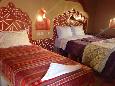 a hotel room with two beds and a bedskirts at Kasbah Ifri in Amdnarene