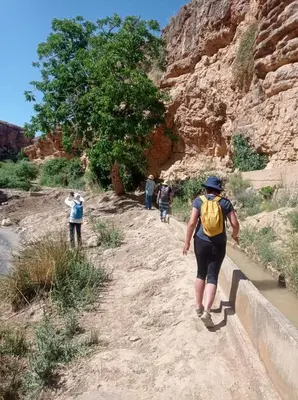 a woman walking down a dirt path in a canyon at Gite Vanadenite in Midelt