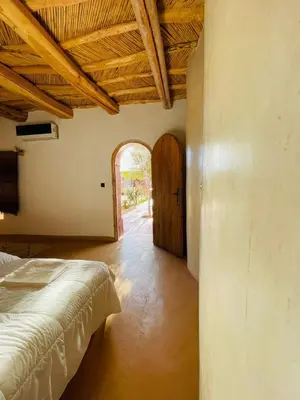 a bedroom with a bed and an open doorway at Riad Ecobio in Aït Yous