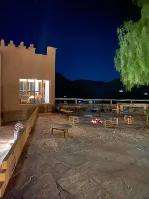 a building with a bench and chairs at night at Riad Ecobio in Aït Yous