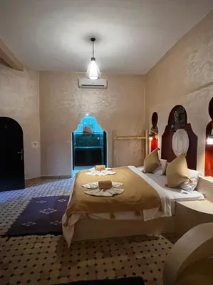 a bedroom with a large bed in a room at Hotel Cafe Du Sud in Merzouga