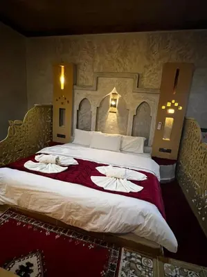 a large bed in a hotel room with towels on it at Hotel Cafe Du Sud in Merzouga