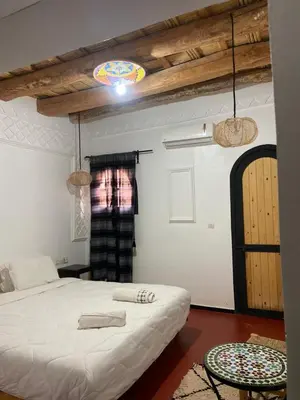 a bedroom with a white bed in a room at Hotel Atlas Gorge Dades in Boumalne