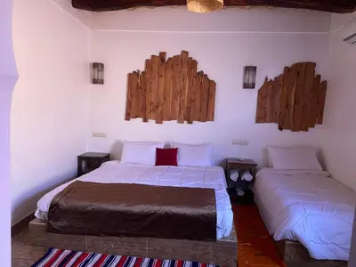 a bedroom with two beds and two mirrors on the wall at Hotel Atlas Gorge Dades in Boumalne