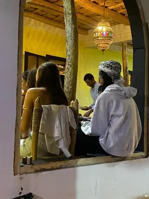 a group of people sitting in a barber shop at Hotel Atlas Gorge Dades in Boumalne