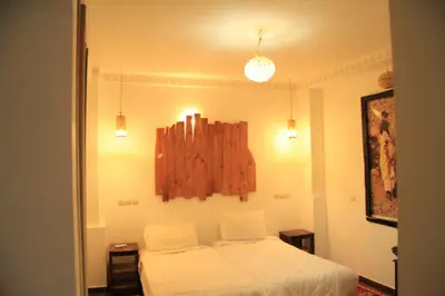 a bedroom with a bed and a clock on the wall at Hotel Atlas Gorge Dades in Boumalne