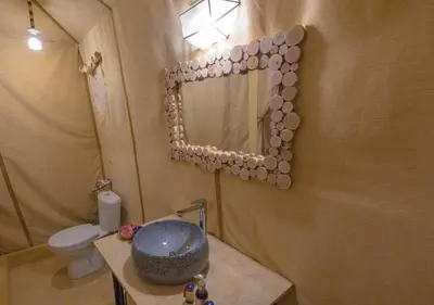 a bathroom with a sink and a mirror and a toilet at Titanic Merzouga Camp in Merzouga