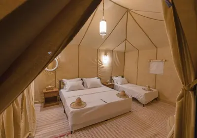 a room with two beds in a tent at Titanic Merzouga Camp in Merzouga