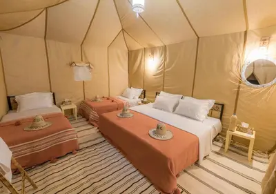 a bedroom with two beds in a tent at Titanic Merzouga Camp in Merzouga