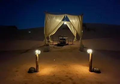 a tent in the middle of the desert at night at Titanic Merzouga Camp in Merzouga