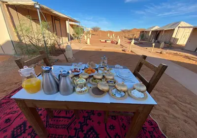 a table with food and pitchers of orange juice on it at Titanic Merzouga Camp in Merzouga