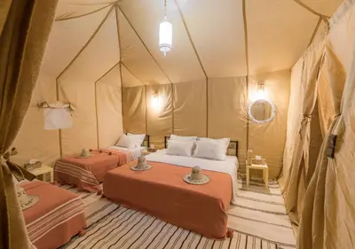 a room with two beds in a tent at Titanic Merzouga Camp in Merzouga