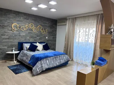 a bedroom with a blue bed and a stone wall at MODERNE APPART PLEIN CENTRE in Fès