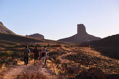 a group of people walking down a dirt road at Land of dreams in Nkob