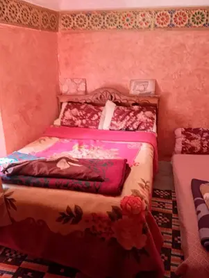 two beds in a room with pink walls at Gite Timit la maison Imazghn in Azilal