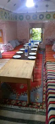 a long wooden table in a room with many tables at Gite Timit la maison Imazghn in Azilal