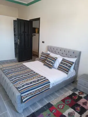 a bedroom with a large bed with a black door at Appartement Hassilabiad-Erg Chebbi in Hassilabied