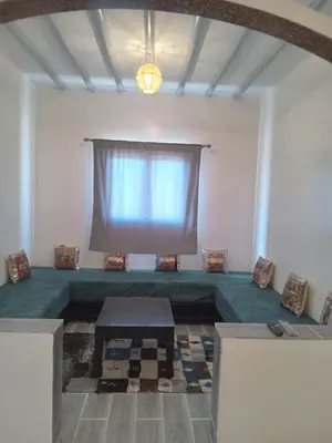 a living room with a table and a window at Appartement Hassilabiad-Erg Chebbi in Hassilabied