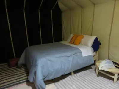 a bedroom with a large bed in a tent at Epic Erg Chigaga Desert Camp in El Gouera