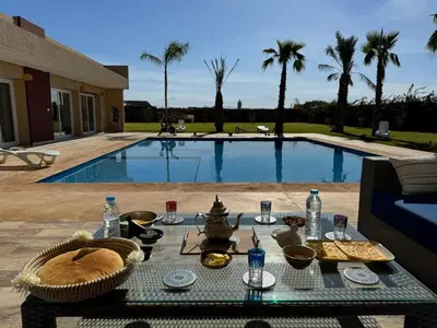 a table with food on it next to a swimming pool at Bienvenu chez VillAtlas in Marrakech