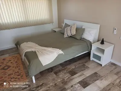 a bedroom with a large bed with a night stand at Bienvenu chez VillAtlas in Marrakech