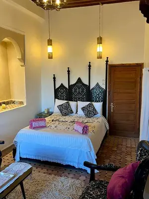a bedroom with a large bed with pink pillows on it at DAR Naima in Fès