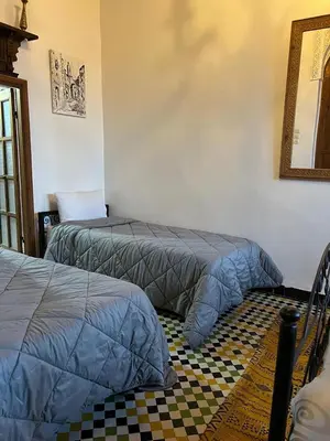 two beds sitting next to each other in a room at DAR Naima in Fès