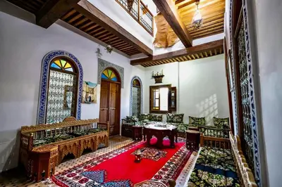 a living room filled with furniture and a red rug at DAR Naima in Fès