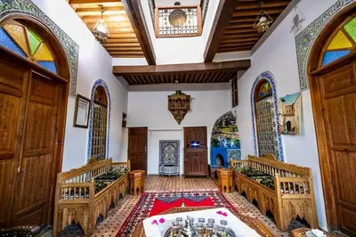 an ornate room with tables and chairs in a building at DAR Naima in Fès