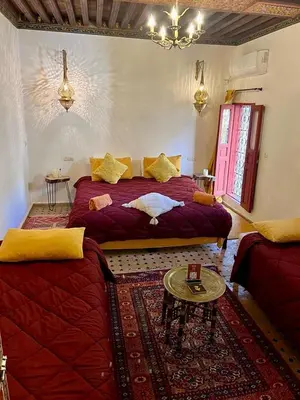 a bedroom with a large bed and a couch at DAR Naima in Fès