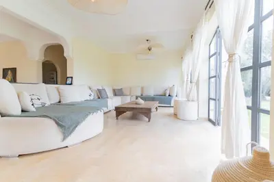 a living room with white furniture and large windows at Villa Daïs - Marrakech in Marrakech