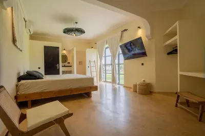 a bedroom with a bed and a chair in it at Villa Daïs - Marrakech in Marrakech