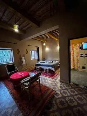 a bedroom with a bed and a table in a room at Serdrar Camp in Timganine