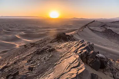 a mountain in the desert at sunset at Serdrar Camp in Timganine
